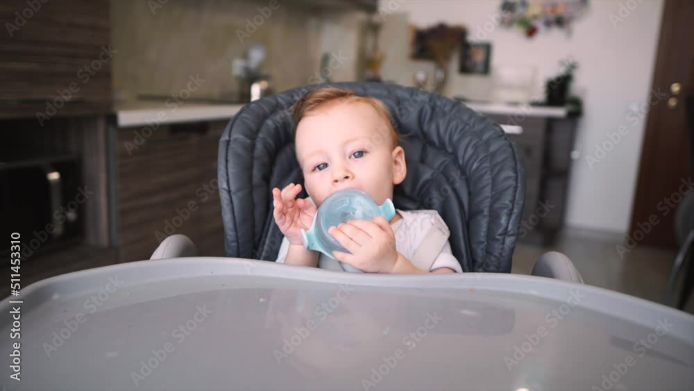 Father gives little baby water from baby bottle cute six month old baby boy drinking fresh water. Father gives little baby water from baby bottle cute six month old baby boy drinking fresh water.
