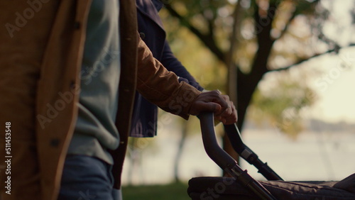 Parents hands pushing carriage walking park closeup. Unconditional love concept.