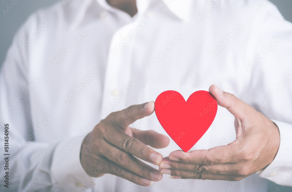 young businessman holding a red heart young businessman holding a red heart