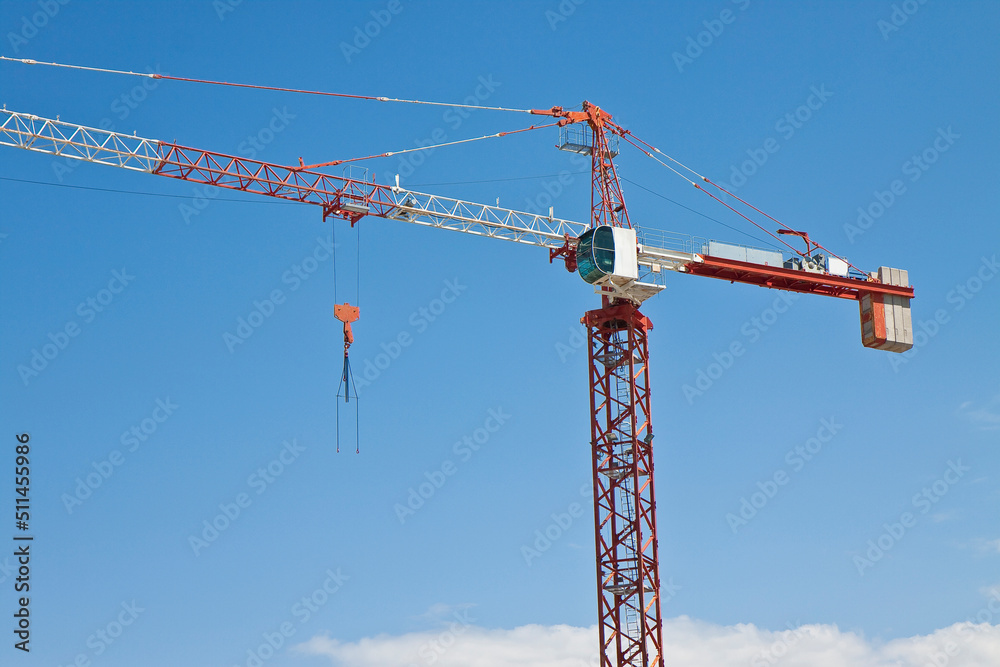 Tower crane in a construction site against a blue sky