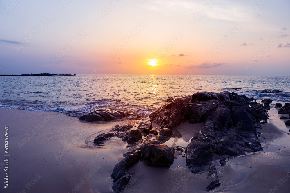Sunset on tropical island in south of Thailand, peaceful rock beach with beautiful sunset