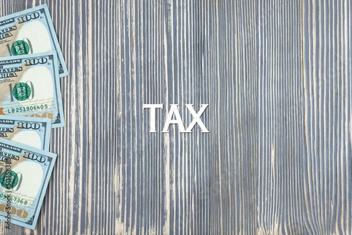 TAX - word  text  on wooden background  money  dollars. Business concept  copy space .