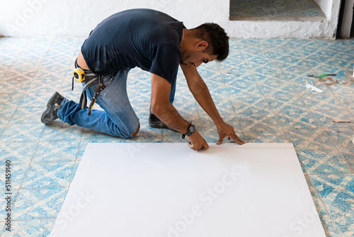 Worker cutting plasterboard with construction knife. Wall renovation