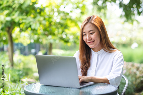 Portrait image of a businesswoman working on laptop computer in the outdoors
