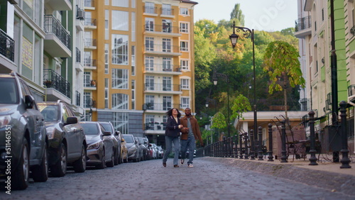 Girlfriend boyfriend enjoy date walking modern residential complex together.