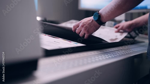 A worker in the printing house checks the quality of the printed packaging.