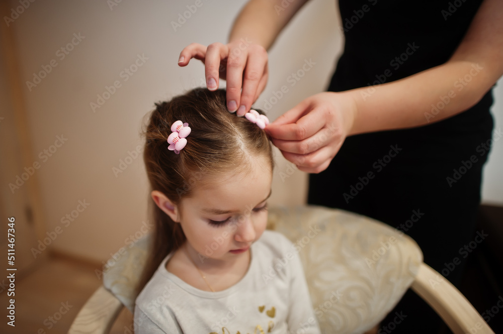Fototapeta premium Mother and daughter weekend together at home, mom making hairstyle.
