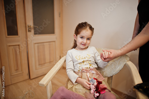 Mom making hairstyle, girl with hairpins.