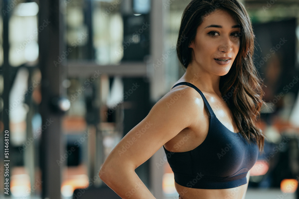 Portrait of a fit sportswoman posing in a gym and looking at the camera. Portrait of a fit sportswoman posing in a gym and looking at the camera.
