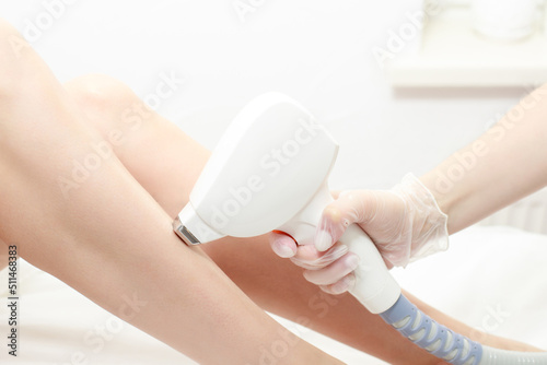 Fotografía Diode laser hair removal, Beautician removes hair on beautiful female legs