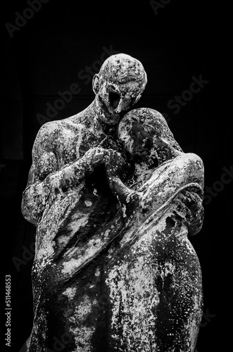 La scultura di bronzo di due amanti che si abbracciano e si tengono per mano su una tomba del cimitero monumentale di Milano
