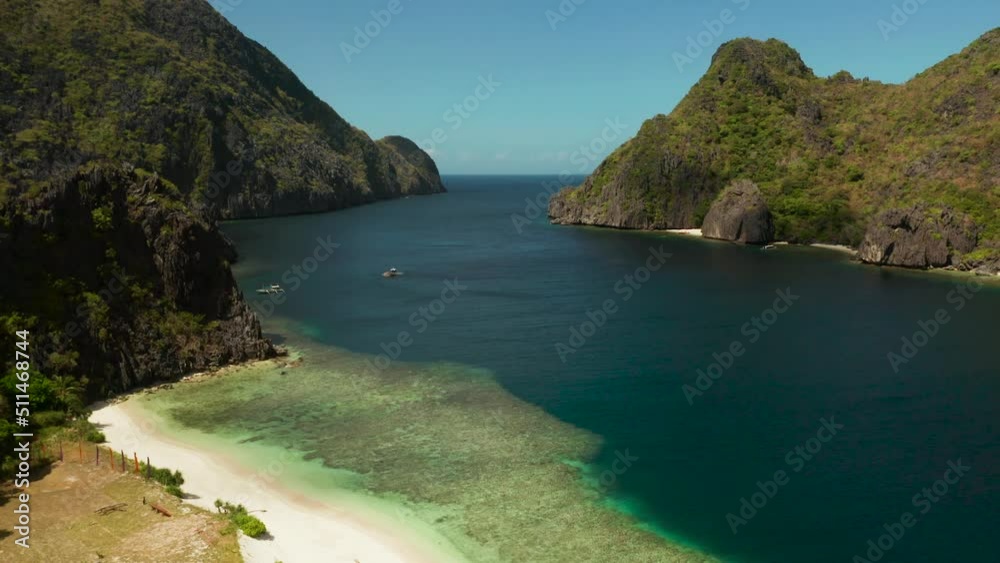 Aerial drone tropical landscape bay with beach and clear blue water surrounded by cliffs. El nido, Philippines, Palawan. Seascape with tropical rocky islands, ocean blue water. Summer and travel Aerial drone tropical landscape bay with beach and clear blue water surrounded by cliffs. El nido, Philippines, Palawan. Seascape with tropical rocky islands, ocean blue water. Summer and travel