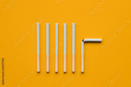 broken cigarette on a yellow background. No smoking concept