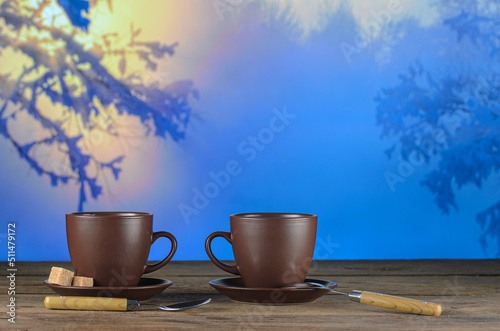 Two cups of tea on background of a winter landscape