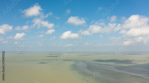 Surface of blue ocean with waves and blue sky with cloud, aerial view. Water cloud horizon background. Blue sea water with waves against sky. © Alex Traveler