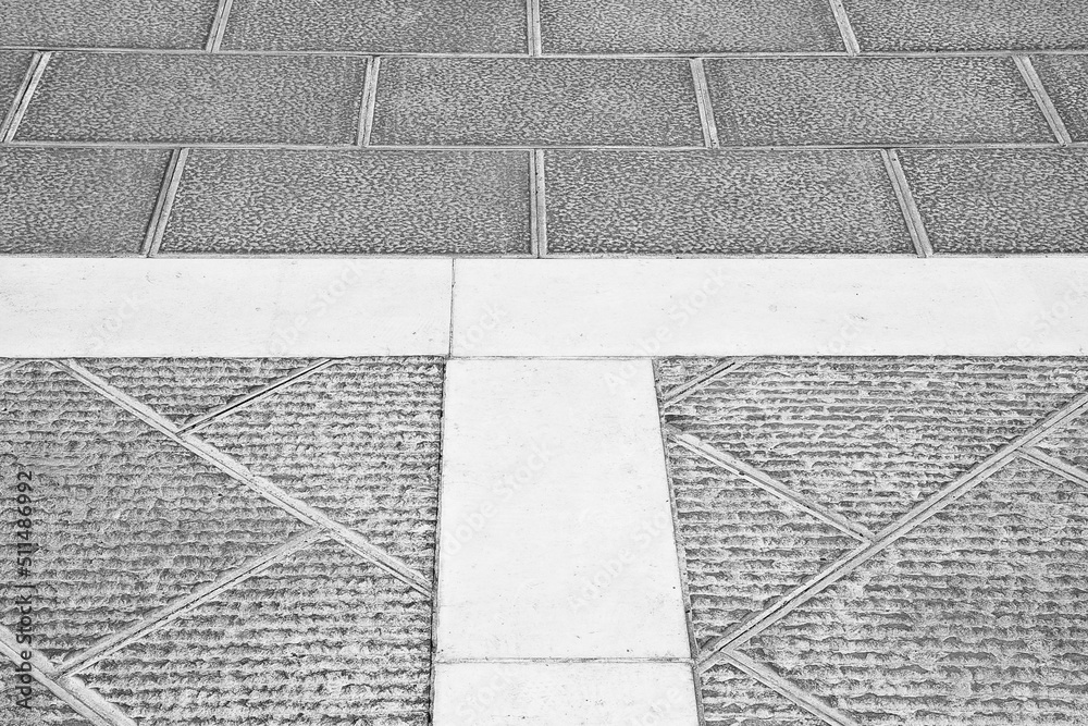 Fototapeta premium New carved paving made with chiseled grey sandstone blocks in a pedestrian zone