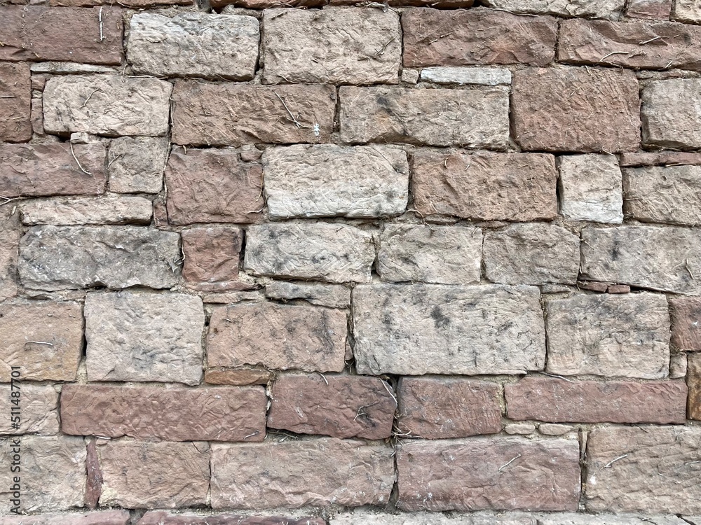 A sandstone wall made of rectangular blocks of different sizes A sandstone wall made of rectangular blocks of different sizes