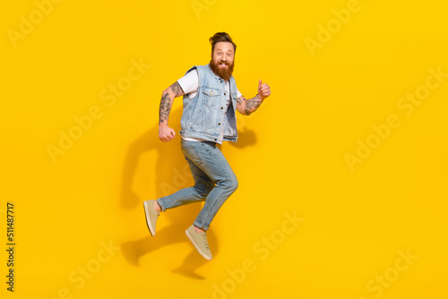 Full size portrait of energetic active person running jumping have fun isolated on yellow color background © deagreez