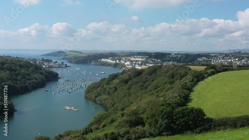 Wide aerial sliding shot over the landscape surrounding the River Fowey, Revealing the Cornish town of Fowey in Cornwall, UK photo