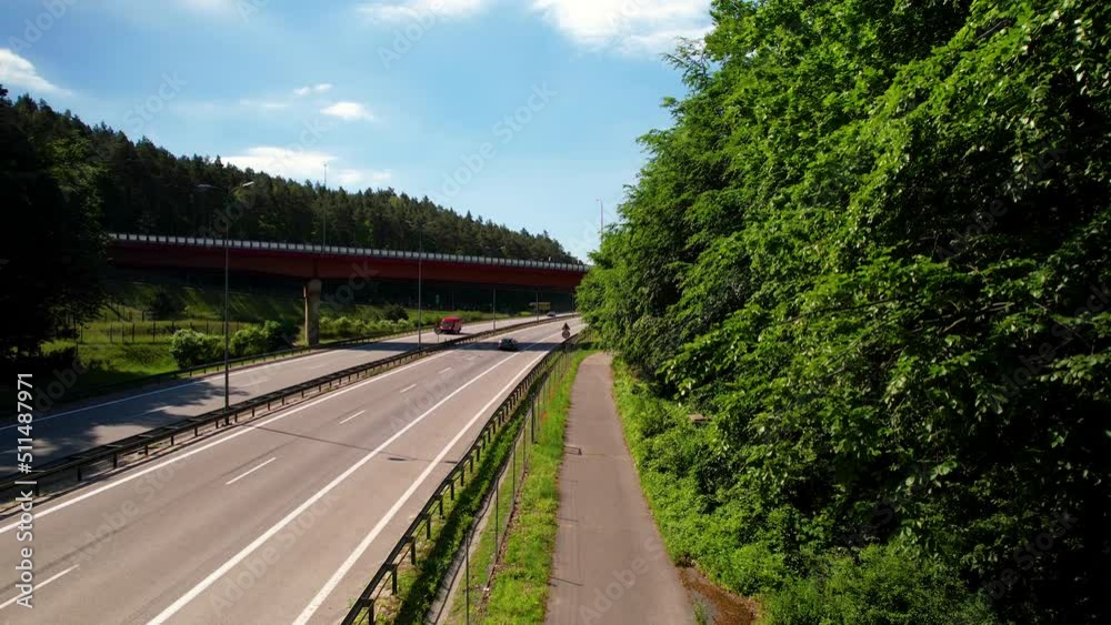 Cars Driving European Route E28 From Roadside With Green Trees In Gdynia, Poland. - aerial ascend Cars Driving European Route E28 From Roadside With Green Trees In Gdynia, Poland. - aerial ascend