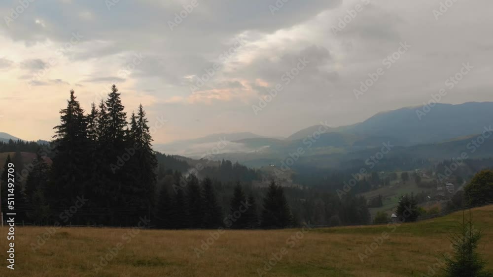 Clouds roll over woods. Inspirational wanderlust destination concept. Epic footage of fog, deep and wild green pine forest high in mountains Carpathians, summer or autumn national park, reserve Clouds roll over woods. Inspirational wanderlust destination concept. Epic footage of fog, deep and wild green pine forest high in mountains Carpathians, summer or autumn national park, reserve