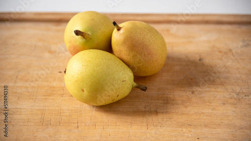 Ripe yellow pears on display on wooden cutting board