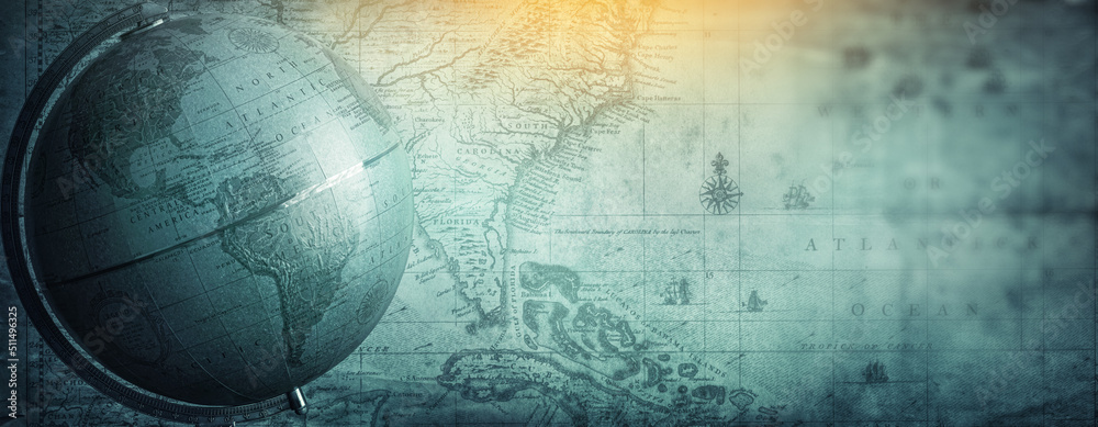 Ancient globe on the old map background. Selective focus. Retro style. Science, education, travel, vintage background. History and geography team. Blue tinted. - obrazy, fototapety, plakaty 