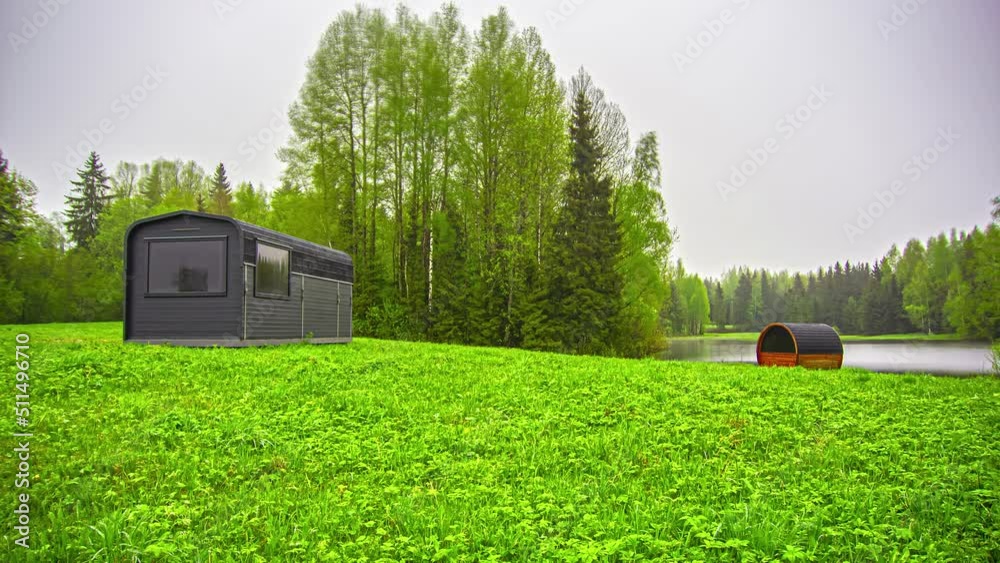 Thermal Wood Cabin With Thermowood Barrel Sauna On Greenery Landscape During Misty Sunrise. Timelapse Thermal Wood Cabin With Thermowood Barrel Sauna On Greenery Landscape During Misty Sunrise. Timelapse