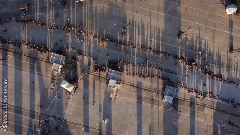 Aerial drone top down pov over long queue of people waiting in Buenos Aires at sunset. Argentina