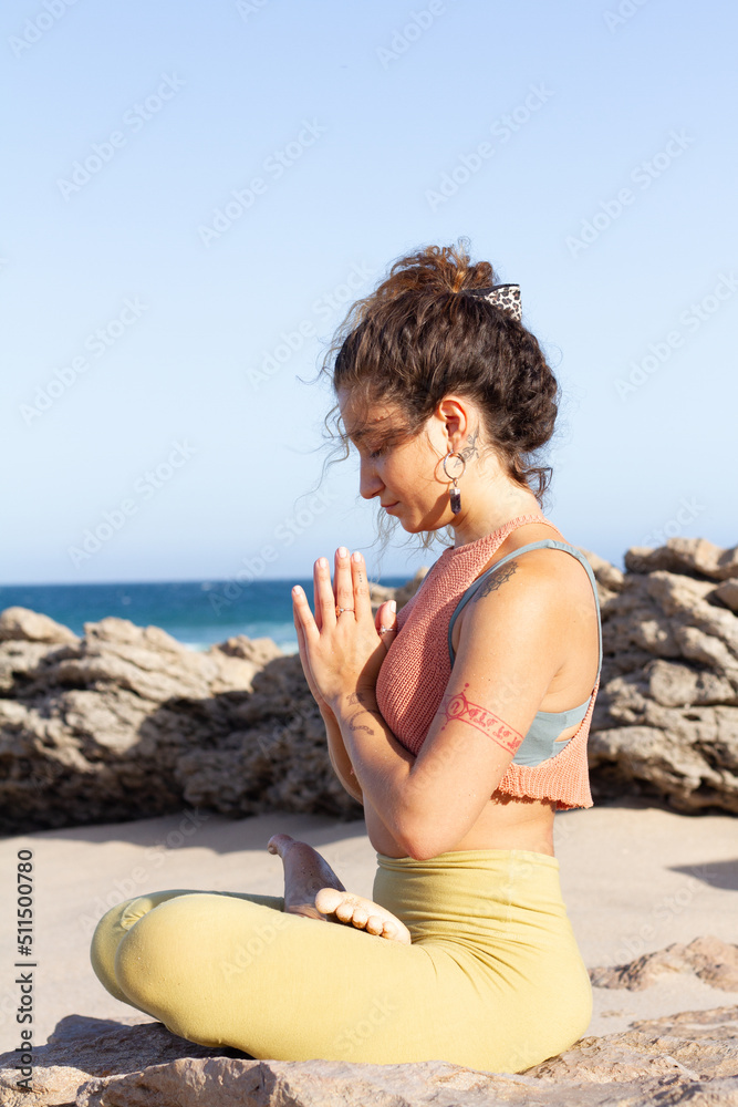 Inspired young woman doing yoga pose in a zen state in the beach in front of ocean - Praia do Gincho - Portugal Inspired young woman doing yoga pose in a zen state in the beach in front of ocean - Praia do Gincho - Portugal