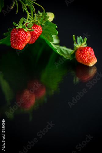 Ripe juicy red strawberry on black background