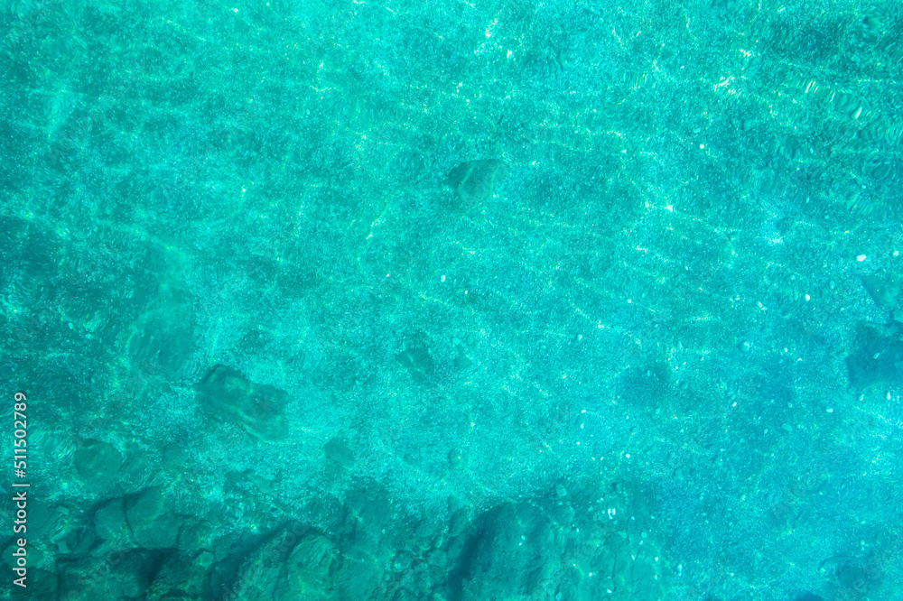 Blue, turquoise transparent water surface of ocean, sea, lagoon. Horizontal background. Top view of sand beach. Aerial, drone view Blue, turquoise transparent water surface of ocean, sea, lagoon. Horizontal background. Top view of sand beach. Aerial, drone view
