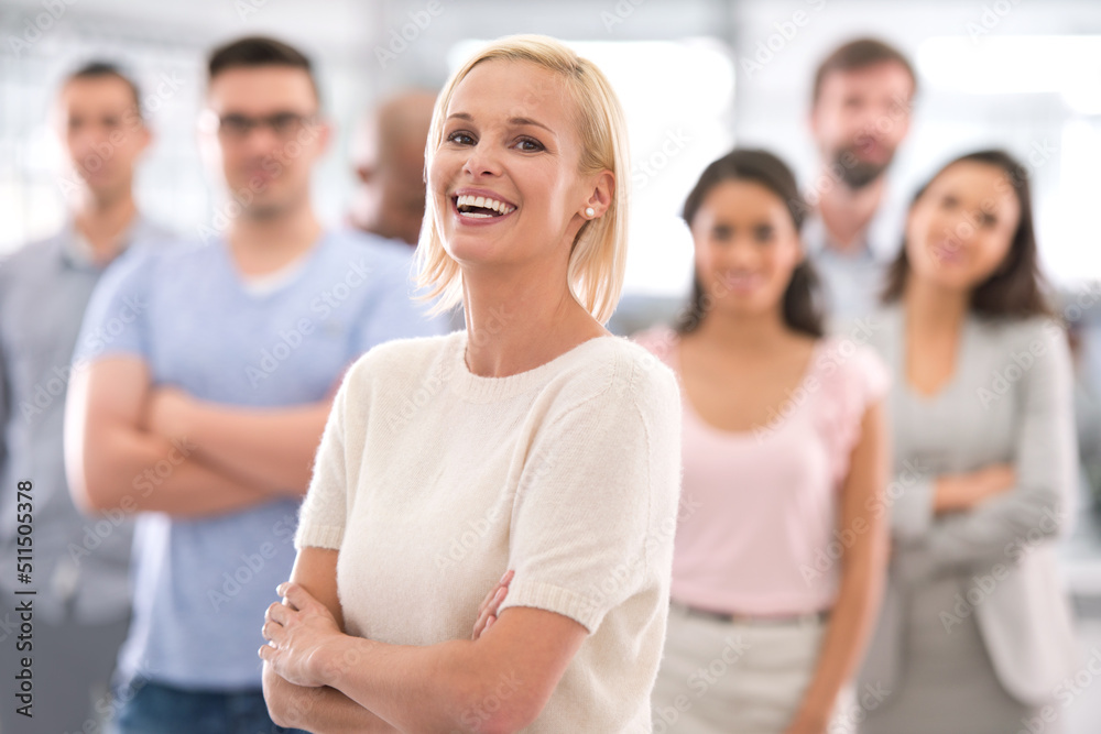 You can take this smile to the bank. Shot of a smiling businesswoman standing in front of her coworkers. You can take this smile to the bank. Shot of a smiling businesswoman standing in front of her coworkers.