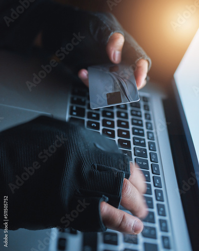 Hackers know exactly how to manipulate financial data. Shot of an unrecognisable hacker using a laptop to hack into a credit account. photo