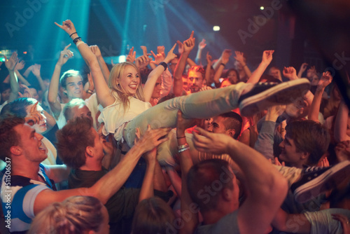 Own the night. Cropped shot of a woman crowd surfing at a music festival.