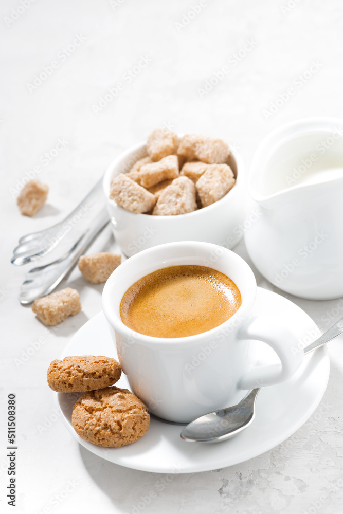 cup of espresso and almond cookies on a white table, vertical, top view cup of espresso and almond cookies on a white table, vertical, top view