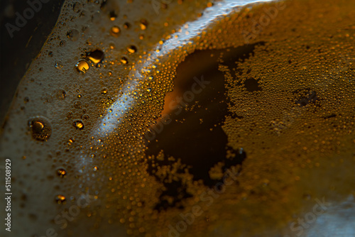 Close up frothy beer bubbles in macro. Circles in blur
