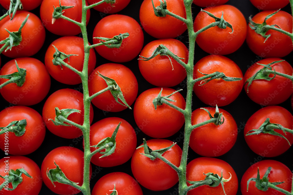 Top view of ripe cherry tomatoes on branches isolated on black. Top view of ripe cherry tomatoes on branches isolated on black.