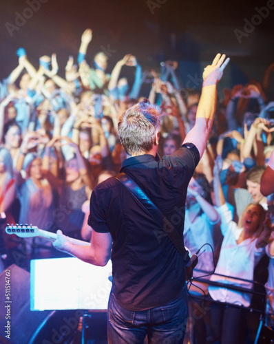 See it from the bands perspective. Rear view of a band performing on stage to their fans.