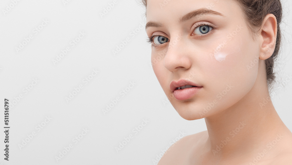Close up shot of a beautiful young woman with smear of a face cream on her cheek. Copy space on the left. Close up shot of a beautiful young woman with smear of a face cream on her cheek. Copy space on the left.