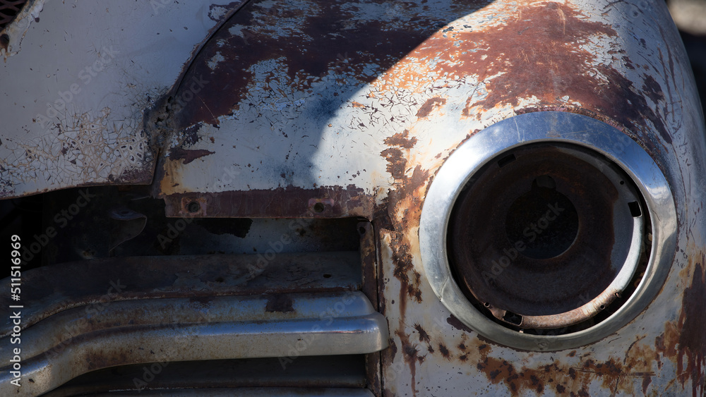 Broken headlight on a rusty car