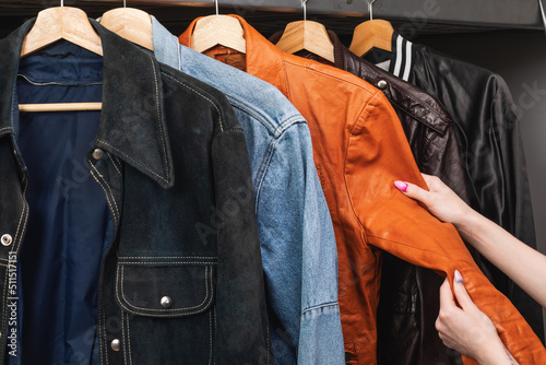 Woman choosing vintage jacket in a used goods store