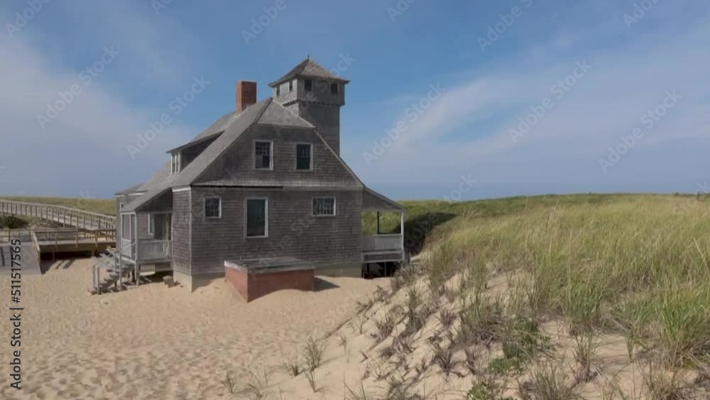 Blue sky and dunes with grass in front of the life saving station building in Provincetown Blue sky and dunes with grass in front of the life saving station building in Provincetown