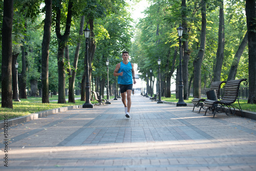 athletic man runner running in sportswear outdoor. full length © Olena