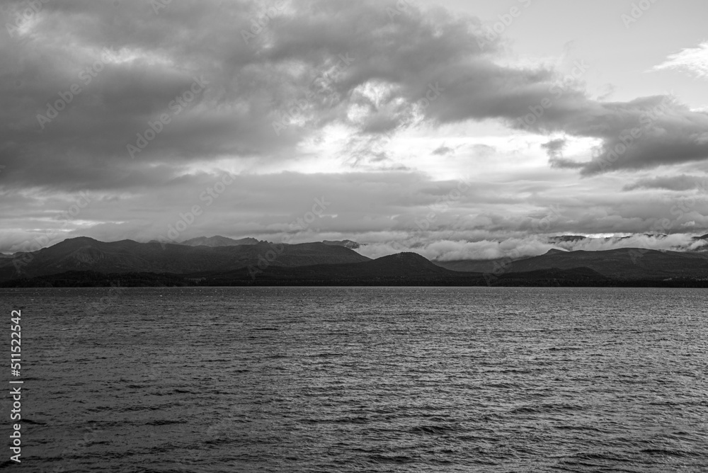 View of Lake Nahuel Huapi with the cloud-covered mountains in the background