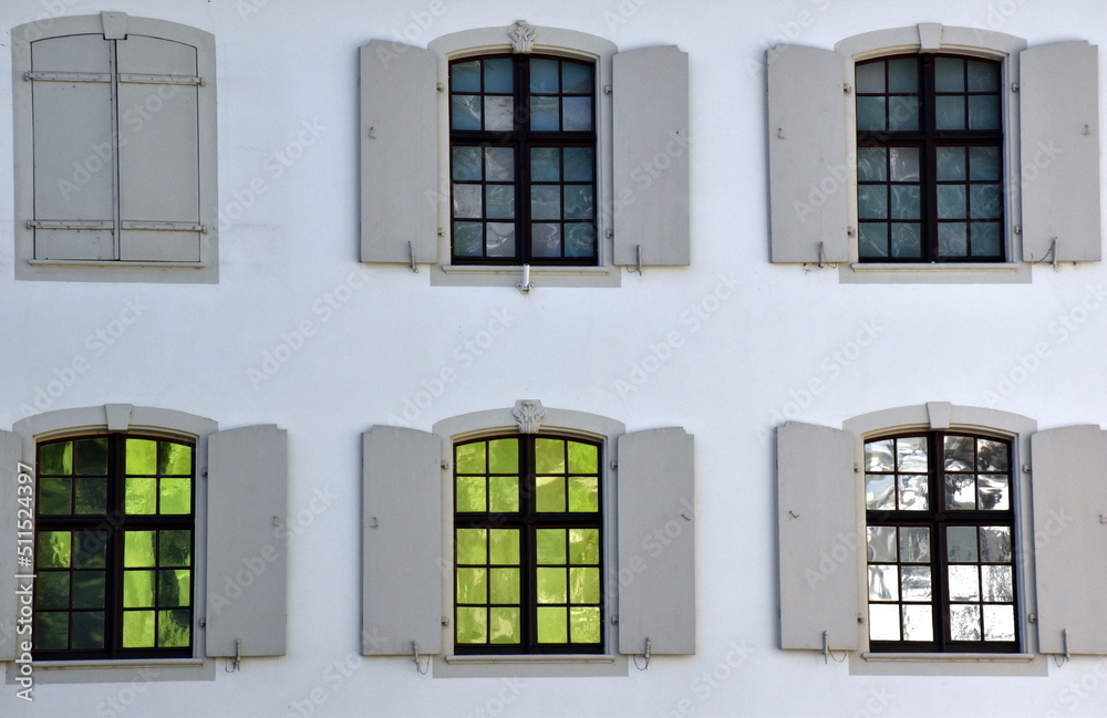 Hausfassade mit bunten Fensterscheiben in Basel