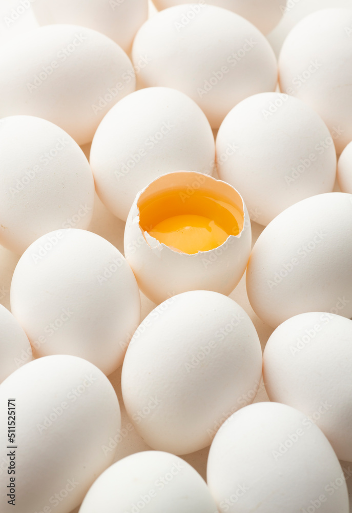 White eggs on a white background, one egg is broken, unlike the others. White eggs on a white background, one egg is broken, unlike the others.