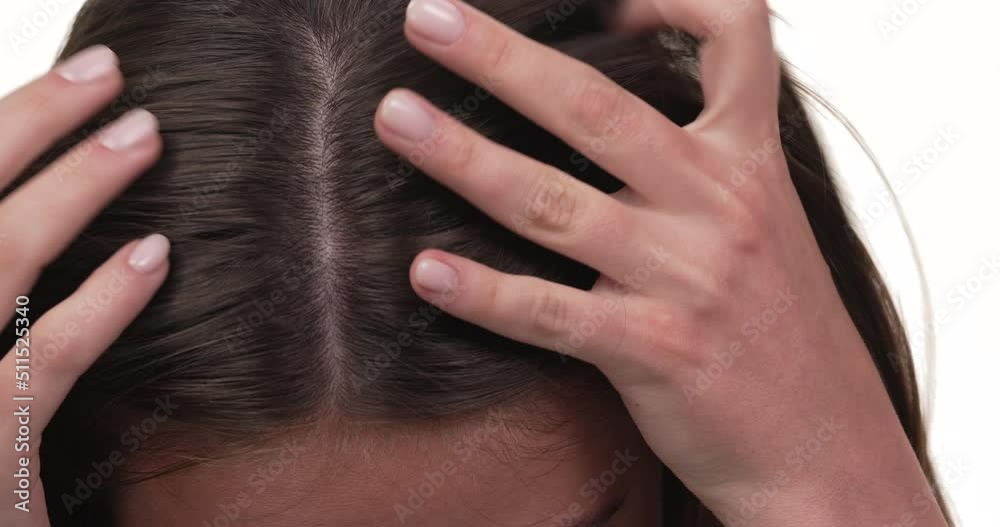 Close up of a woman's hands checking her hair on her head. Isolated on white background. Close up of a woman's hands checking her hair on her head. Isolated on white background.