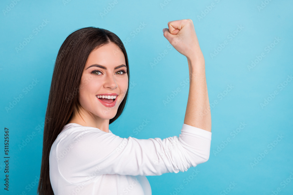 Profile side view portrait of attractive cheerful successful girl celebrating having fun isolated over vibrant blue color background Profile side view portrait of attractive cheerful successful girl celebrating having fun isolated over vibrant blue color background