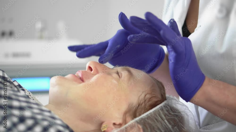 Hardware procedure in cosmetology. Cosmetologist smoothes wrinkles with microcurrent. Peeling, phonophoresis, massage and facelift in a beauty clinic. Hardware procedure in cosmetology. Cosmetologist smoothes wrinkles with microcurrent. Peeling, phonophoresis, massage and facelift in a beauty clinic.